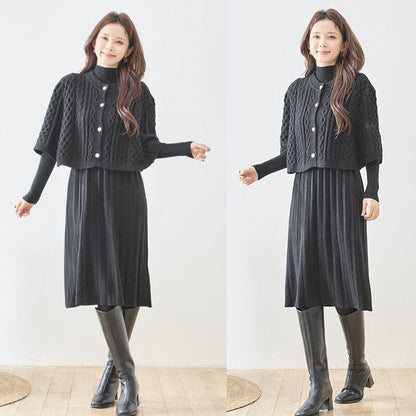 Mikonosublue Storeの黒いケーブル編みボレロとリブニットワンピースのセットアップを着用した女性