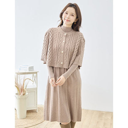 Mikonosublue Storeのベージュのケーブル編みボレロとリブニットワンピースのセットアップを着用した女性