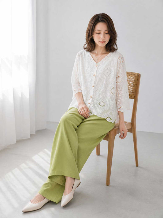 Mikonosublue Storeの白いコットン製カットワーク刺繍ブラウス。Vネックと七分袖で、涼しげな透け感のあるデザイン。