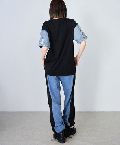Mikonosublue Storeのダメージデニム袖が特徴的な黒のドッキングTシャツを着用した女性の背面ショット