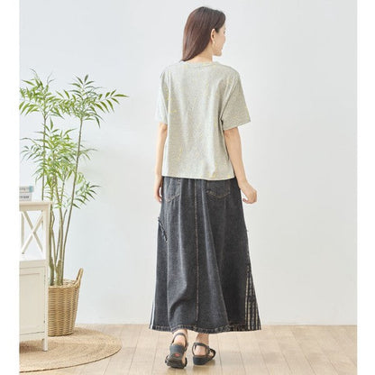 Mikonosublue Storeのデニムとチェック柄を切り替えたパッチワークマキシスカートを着用した女性の後ろ姿