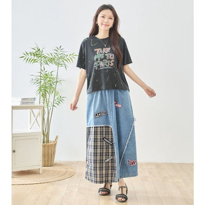Mikonosublue Storeのデニムとチェック柄を組み合わせたパッチワークマキシスカートを着用した女性