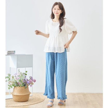 Mikonosublue Storeのドット柄デニムワイドパンツ。裾フリルが可愛い綿100%のゆったりとしたブルーのパンツを着用した女性。