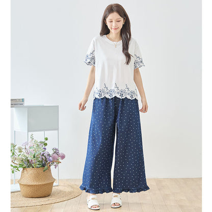 Mikonosublue Storeのドット柄裾フリルデニムワイドパンツ。ウエストゴムでゆったりとした綿100%のネイビーパンツを着用したモデル。