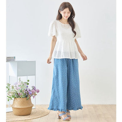 Mikonosublue Storeのドット柄裾フリルデニムワイドパンツ。綿100%のブルーデニムに白いドットと裾のフリルが特徴で、ウエストゴムのゆったりとしたシルエットが体型をカバーします。