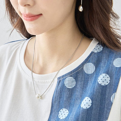 Mikonosublue Storeの無地とドット柄の異素材切り替えが特徴的な半袖トップス。アシンメトリーなデザインでゆったりとしたシルエット。