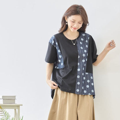 Mikonosublue Storeの黒い半袖トップス。無地とドット柄の異素材切り替えが特徴のゆったりとしたAラインシルエット。