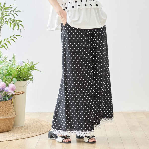 Mikonosublue Storeのポルカドット柄ワイドパンツ。裾に白いクロシェレースをあしらった黒地に白の水玉模様のゆったりとしたデザイン。