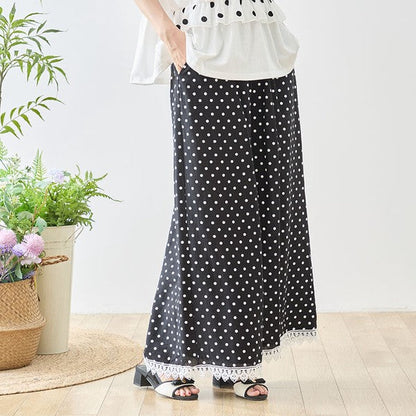 Mikonosublue Storeのポルカドット柄ワイドパンツ。裾に白いクロシェレースをあしらった黒地に白の水玉模様のゆったりとしたデザイン。