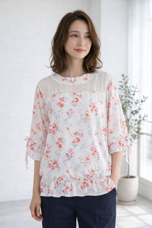 Mikonosublue Storeのデコルテにレースをあしらった上品な花柄ジョーゼットブラウス。七分袖と裾ゴムのペプラム風シルエットが特徴。