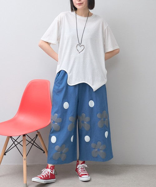 Mikonosublue Storeのフラワーとドット柄がプリントされたデニムライクなワイドパンツ。ゆったりとしたシルエットで夏に涼しい綿混素材。