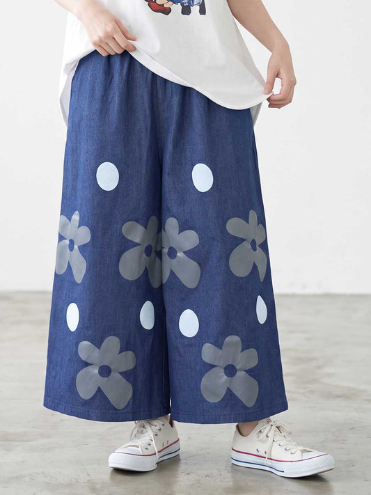 Mikonosublue Storeのフラワーとドット柄がプリントされたデニムライクなワイドパンツ。ゆったりとしたシルエットで夏に涼しい綿混素材。