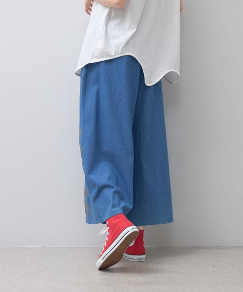 Mikonosublue Storeのフラワーとドット柄がプリントされた涼しげなブルーのワイドパンツを着用した後ろ姿