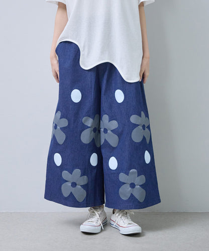 Mikonosublue Storeのフラワーとドット柄がプリントされたデニムライクな綿混ワイドパンツ。ゆったりとしたシルエットで夏に涼しい。