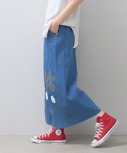 Mikonosublue Storeのフラワーとドット柄がプリントされたデニムライクな青いワイドパンツ。ゆったりとしたシルエットで夏に涼しい綿混素材