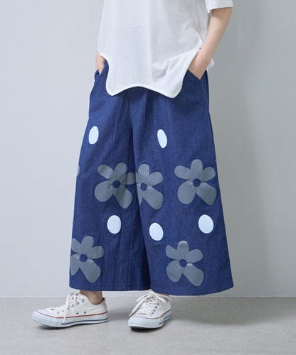 Mikonosublue Storeのフラワーとドット柄がプリントされたデニムライクなワイドパンツ。涼しげな綿混素材でゆったりとしたシルエット。