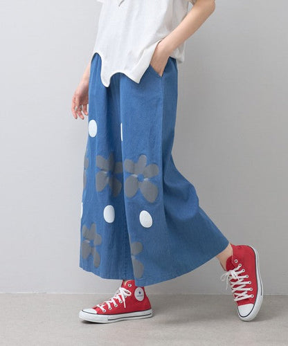 Mikonosublue Storeのフラワーとドット柄がプリントされたデニムライクなワイドパンツ。涼しげな綿混素材でゆったりとしたシルエットが特徴。