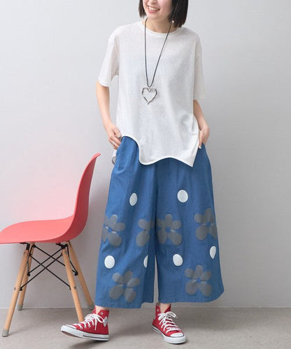 Mikonosublue Storeのフラワーとドット柄がプリントされた涼しげなワイドパンツを履いた女性