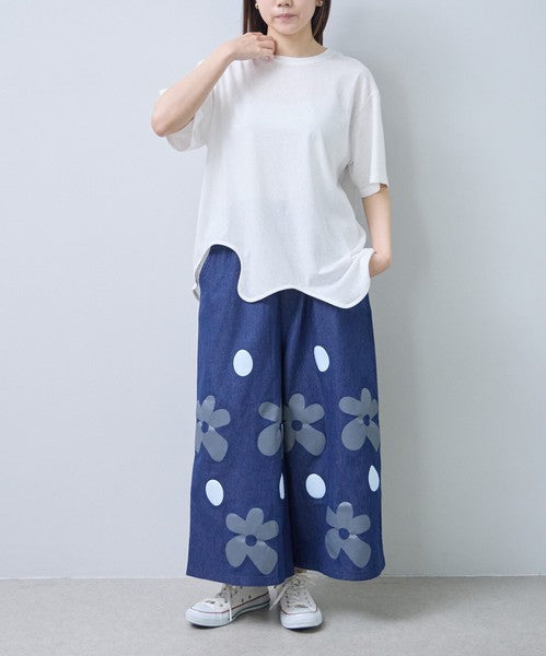 Mikonosublue Storeのフラワーとドット柄がプリントされたデニムライクなワイドパンツ。ゆったりとしたシルエットで涼しく快適な夏用ボトムス