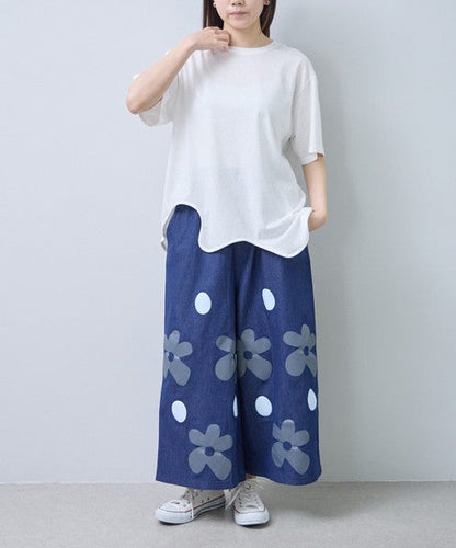 Mikonosublue Storeのフラワーとドット柄がプリントされたデニムライクなワイドパンツ。ゆったりとしたシルエットで涼しく快適な夏用ボトムス