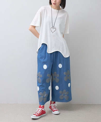 Mikonosublue Storeのフラワーとドット柄がプリントされたブルーのワイドパンツを履いた女性