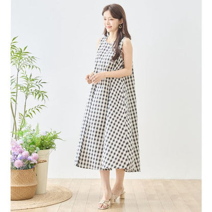 Mikonosublue Storeのギンガムチェック柄ノースリーブマキシワンピース。コットン素材のゆったりとしたフレアシルエットで、モノトーンの爽やかな夏スタイル。