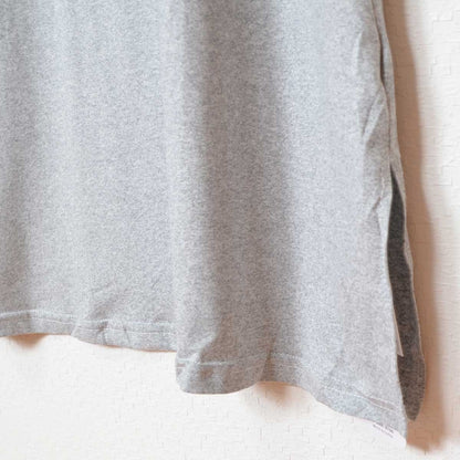 Mikonosublue StoreのグレーのロゴTシャツワンピース。サイドスリット入りでゆったりとしたストレッチ素材のカジュアルなデザイン。