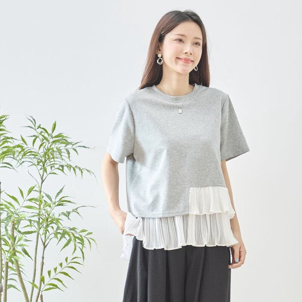 Mikonosublue Storeのグレーの半袖Tシャツ。裾に白いアシンメトリーなプリーツフリルをあしらった異素材切り替えデザイン。