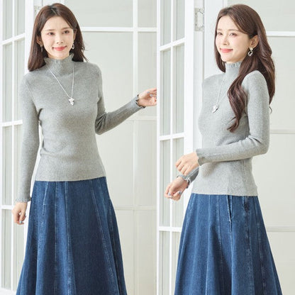 Mikonosublue Storeのグレーのリブニットプルオーバー。首元と袖口にフリルがあしらわれたハイネックデザインで、女性らしいシルエットが特徴。