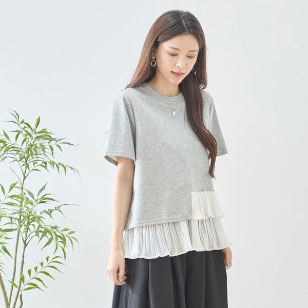 Mikonosublue Storeのグレーの半袖Tシャツ。裾に白いシフォン素材のティアードプリーツフリルが施された異素材切り替えデザイン。