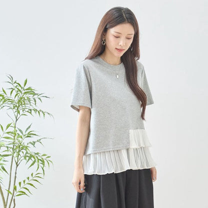 Mikonosublue Storeのグレーの半袖Tシャツ。裾に白いシフォン素材のティアードプリーツフリルが施された異素材切り替えデザイン。