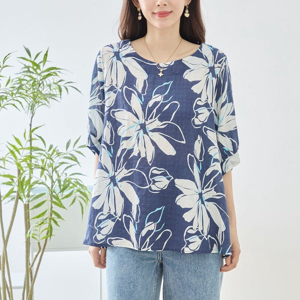 Mikonosublue Storeのネイビー地に白い大きな花柄がプリントされた綿100%のゆったりとしたドルマン袖トップス