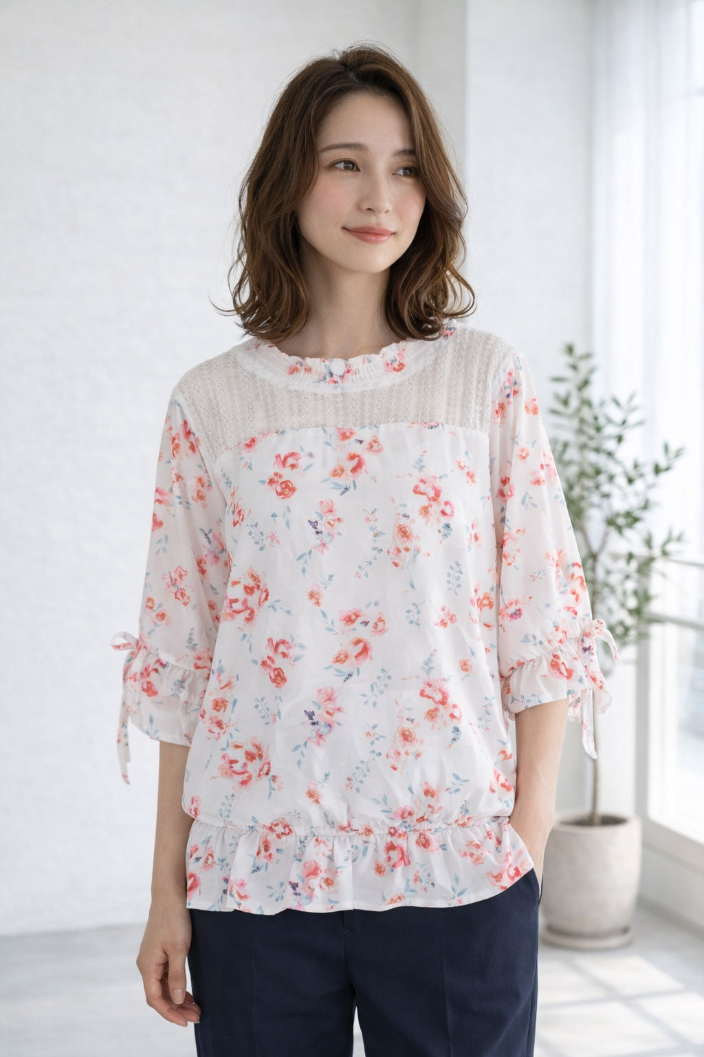 Mikonosublue Storeのデコルテにレースをあしらった花柄ジョーゼットブラウス。七分袖とペプラム風の裾がフェミニンな印象を与える上品なトップス