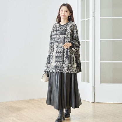 Mikonosublue Storeのモノトーン花柄パッチワーク風チュニックを着用した女性。ゆったりとしたシルエットでリブ切り替えが特徴。