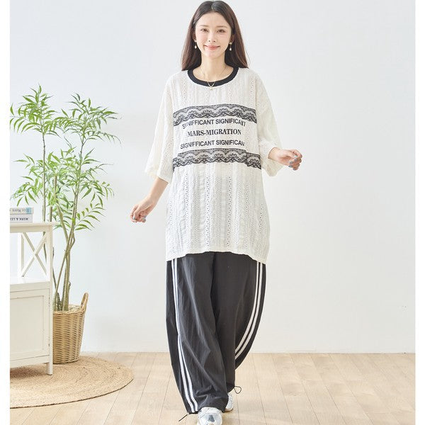 Mikonosublue Storeの胸元にレースとロゴをあしらったアイボリーの透かし編みビッグシルエット半袖トップス