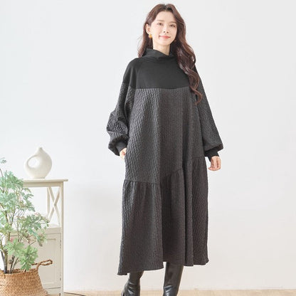 Mikonosublue Storeの異素材切替ロングワンピース。黒のバルーンスリーブとエンボス加工生地が特徴のゆったりとしたモードな秋冬用ドレス。