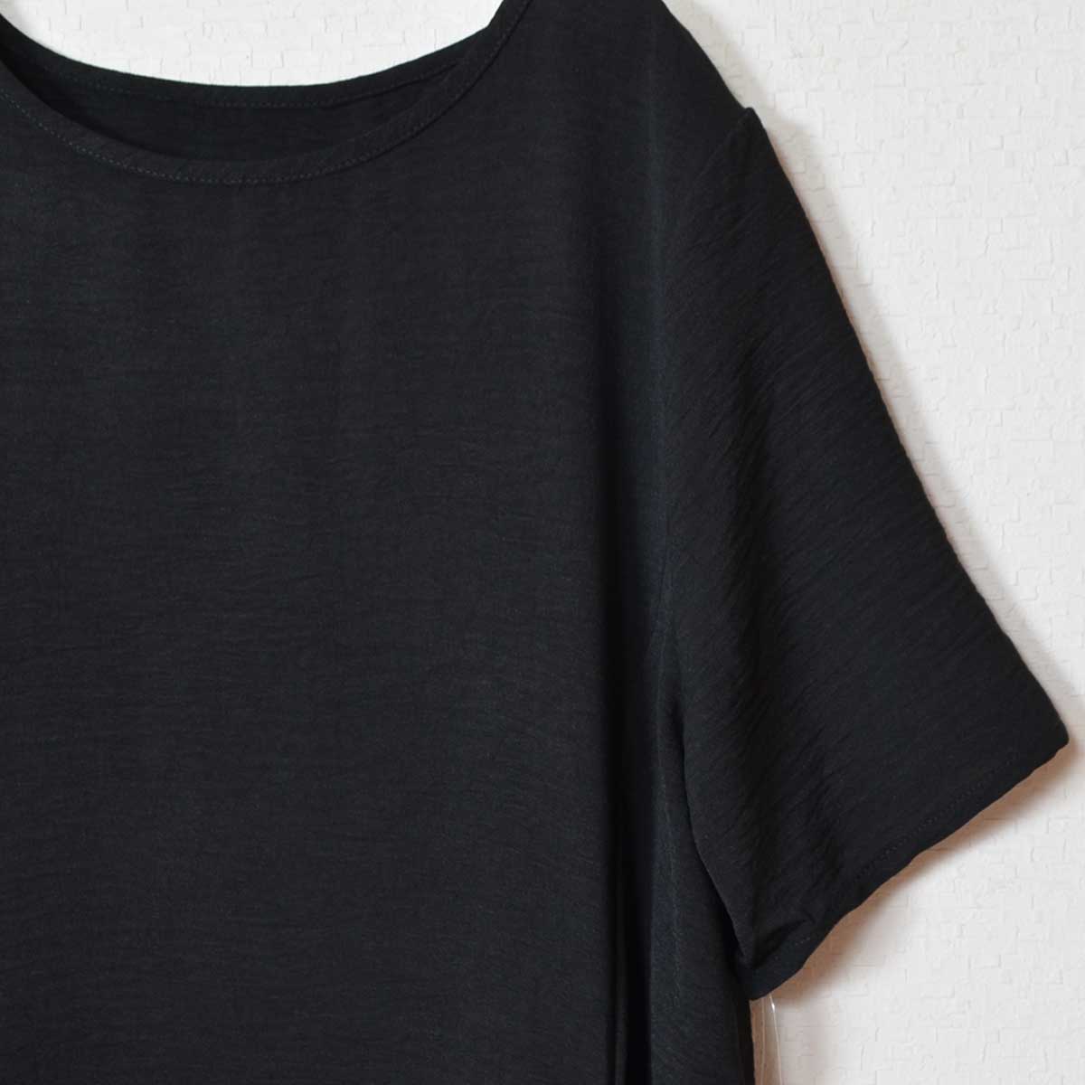 Mikonosublue Storeの黒い半袖ワンピース。さらりとしたポリエステル素材のクルーネックで、ゆったりとしたシルエットが特徴。