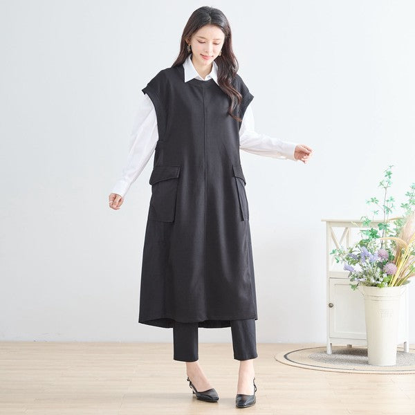 Mikonosublue Storeの黒い異素材切り替えノースリーブロングワンピース。白シャツと合わせたレイヤードスタイルで、Aラインのゆったりとしたシルエットが特徴。