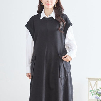 Mikonosublue Storeの黒い異素材切り替えノースリーブワンピース。白シャツを重ね着したAラインのロング丈で、サイドポケットが特徴的な大人カジュアルスタイル。