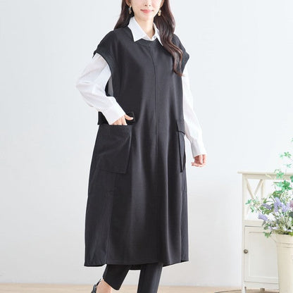 Mikonosublue Storeの黒い異素材切り替えノースリーブワンピース。白シャツと重ね着したAラインのロング丈。