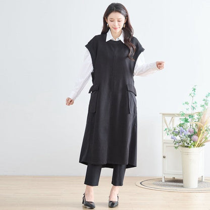 Mikonosublue Storeの黒い異素材切り替えノースリーブロングワンピース。白いシャツを重ね着したAラインの体型カバーシルエット。
