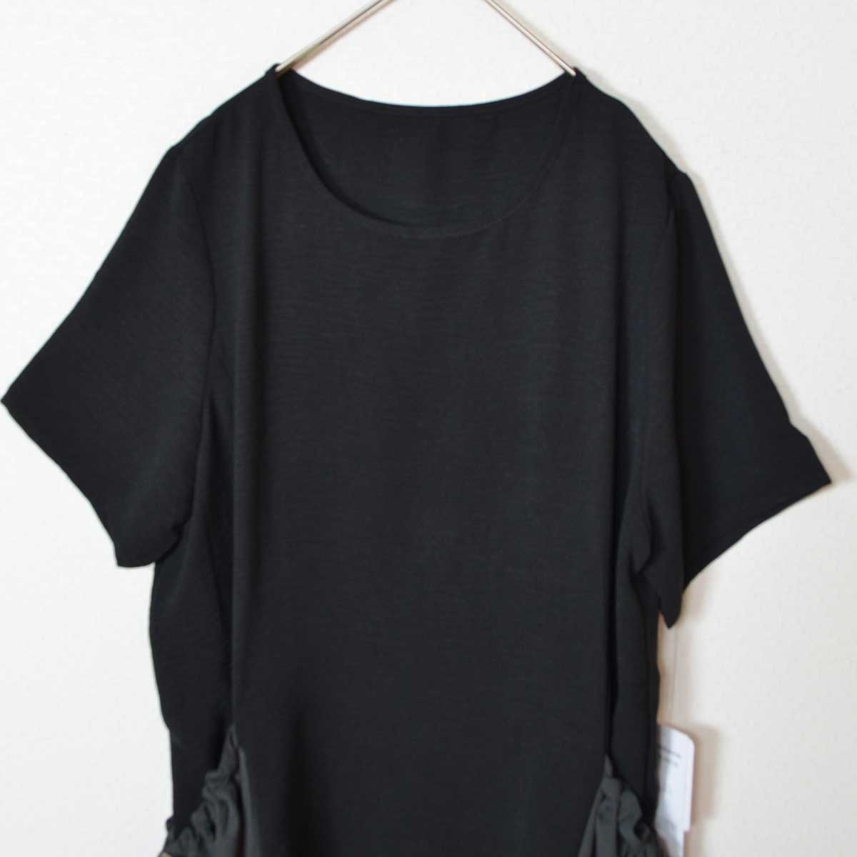 Mikonosublue Storeの黒い半袖ワンピース。両サイドにドロスト付きの異素材ビッグポケットが特徴のゆったりとしたデザイン。