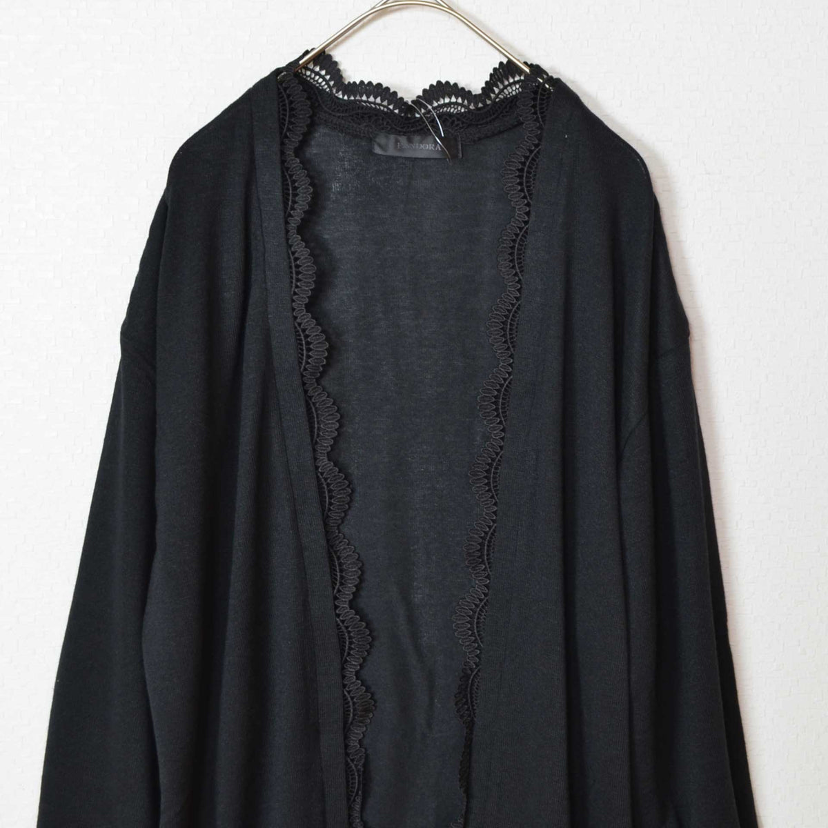 Mikonosublue Storeのブラックの長袖トッパーカーディガン。前立てに繊細なレースがあしらわれたゆったりとしたシルエットの羽織り。