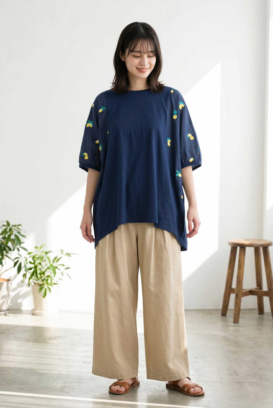 Mikonosublue Storeのレモン刺繍が施されたネイビーの異素材切替ビッグシルエットTシャツを着用した女性