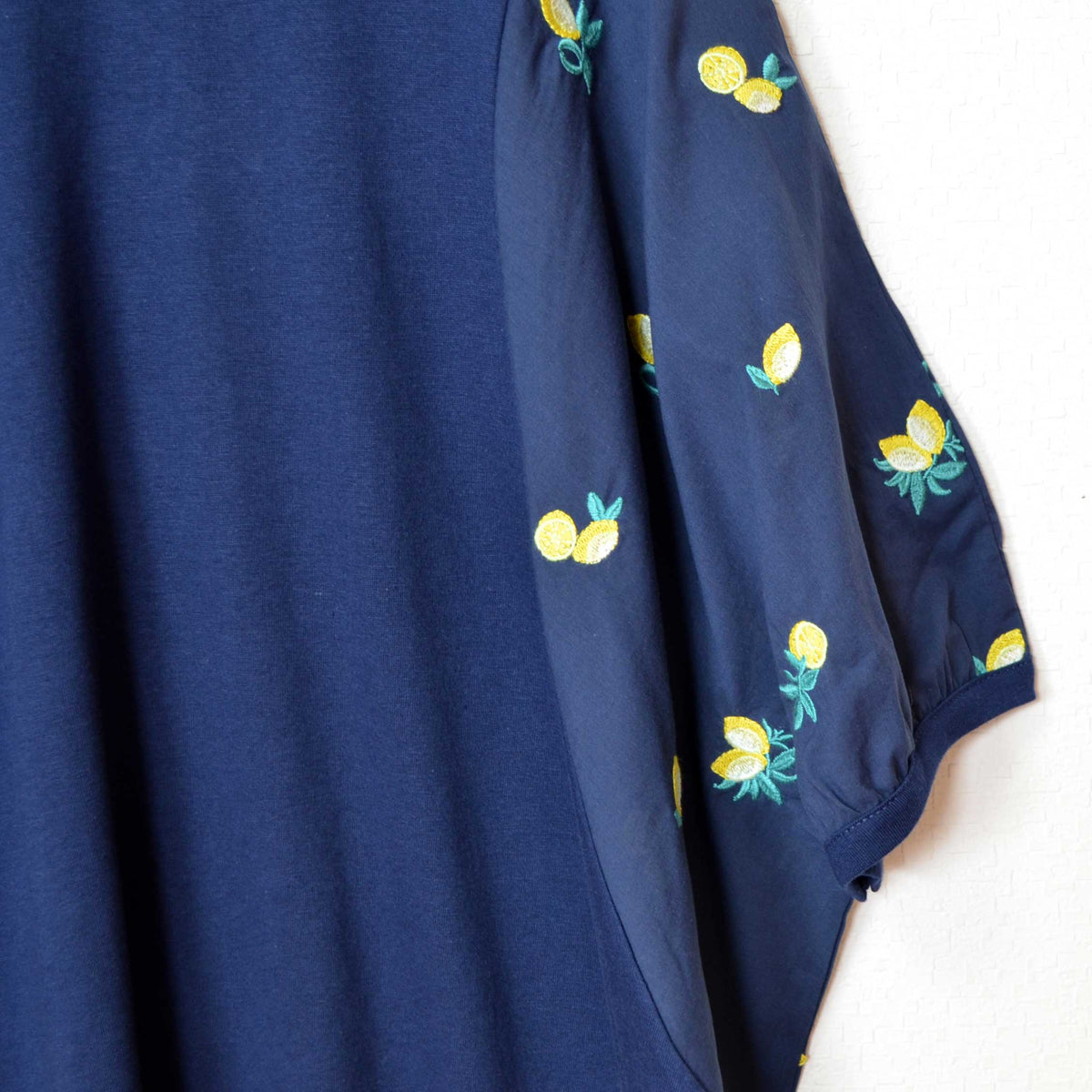 Mikonosublue StoreのネイビーのビッグサイズTシャツ。袖に立体的なレモンの総刺繍が施された異素材切替デザイン。
