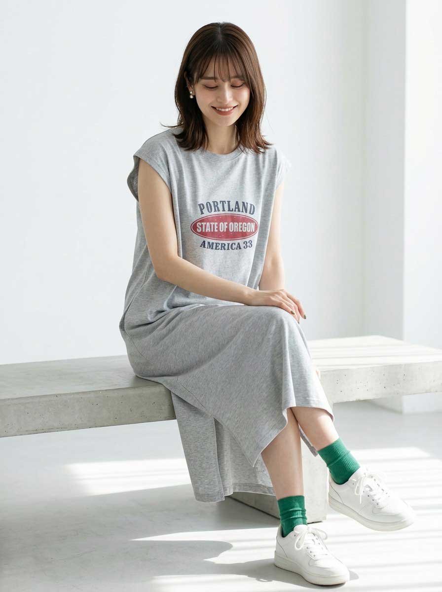 Mikonosublue StoreのグレーのロゴプリントTシャツワンピース。フレンチスリーブとサイドスリットが特徴のゆったりとしたカジュアルなロング丈。