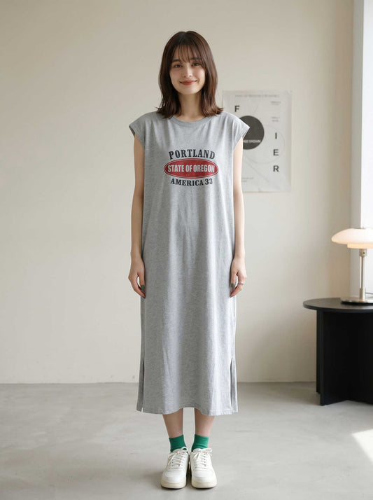 Mikonosublue Storeのグレーのロゴプリント入りフレンチスリーブTシャツワンピース。ゆったりとしたシルエットでサイドスリットがあり、カジュアルでリラックスした着こなし。