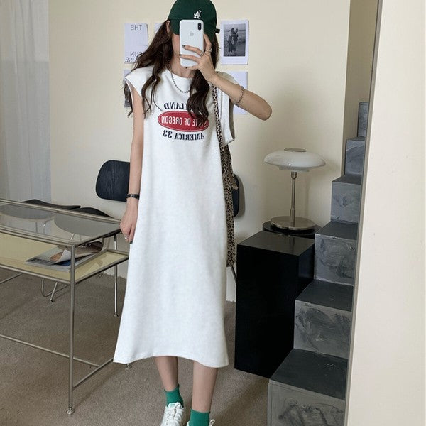 Mikonosublue Storeのロゴプリント入りグレーのフレンチスリーブTシャツワンピース。ゆったりとしたシルエットでサイドスリットがあり、カジュアルな着こなし。