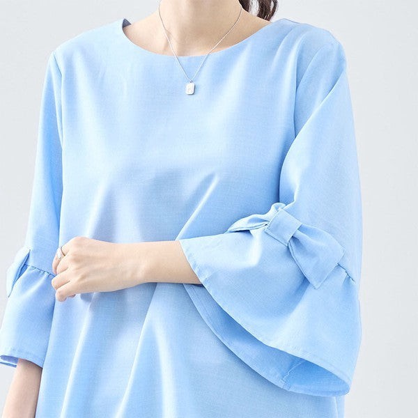 Mikonosublue Storeの袖にリボンがあしらわれた水色の七分袖Aラインチュニックブラウス