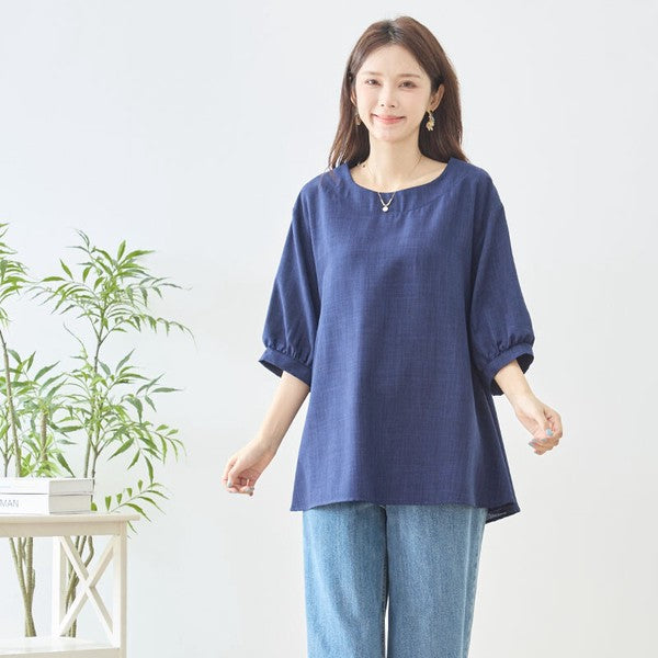 Mikonosublue Storeのネイビーの5分袖Aライントップスを着用した女性。バックフリルが特徴の体型カバーできる夏用ブラウス。